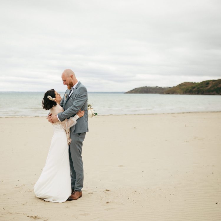 Mariés amoureux enlacés — promenade romantique sur le littoral breton